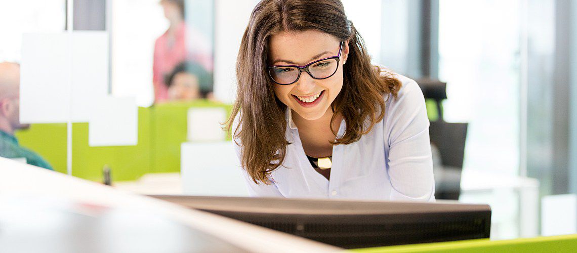 Veterinary practice manager standing at computer.