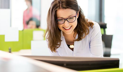 Veterinary practice manager standing at computer.