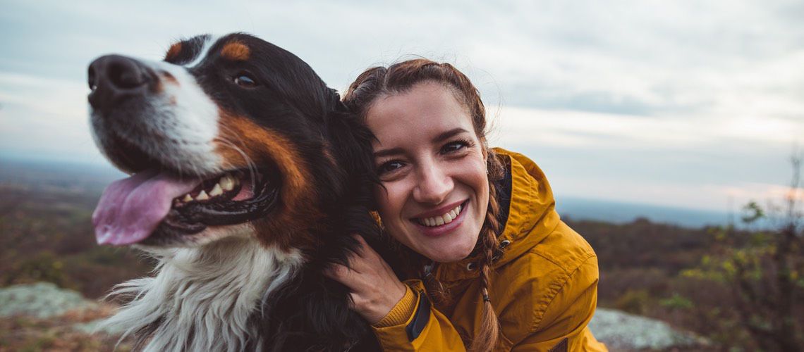 Young woman hugging her dog.