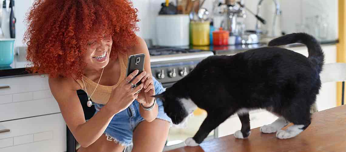 Young Generation Z woman taking a photo of her cat.