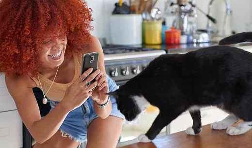 Young Generation Z woman taking a photo of her cat.