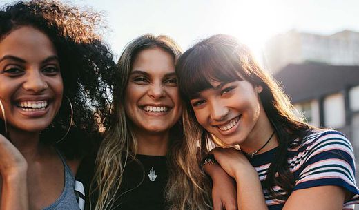 Three young women smiling for the camera.