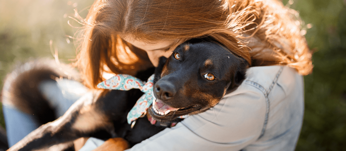 A woman hugs a dog.