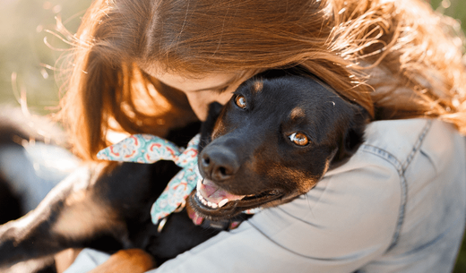 A woman hugs a dog.