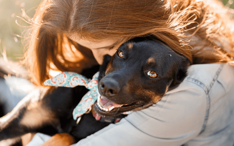 A woman hugs a dog.