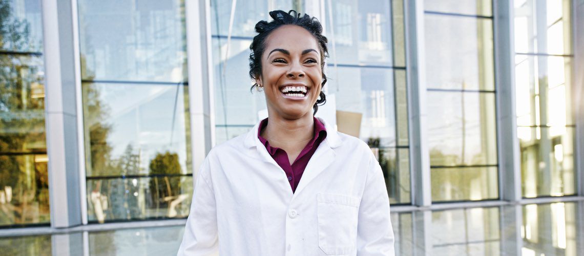 Happy, smiling veterinarian standing in front of the veterinary practice.