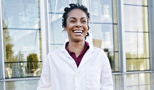 Happy, smiling veterinarian standing in front of the veterinary practice.