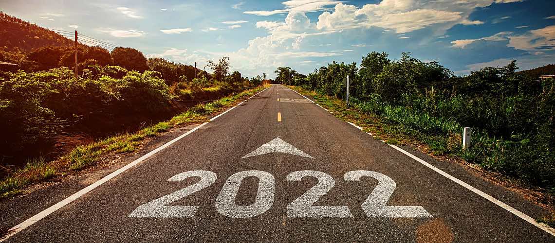 2022 is written on a highway that extends to a horizon of blue sky.