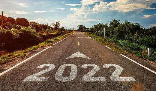 2022 is written on a highway that extends to a horizon of blue sky.