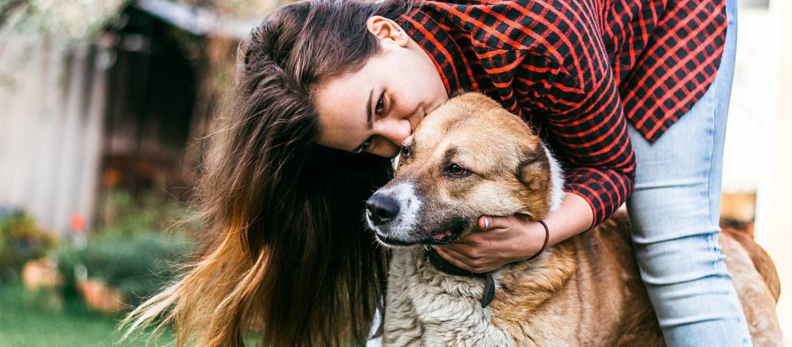 Woman hugging dog.