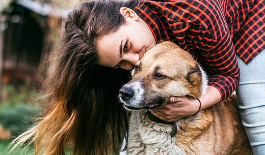 Woman hugging dog.