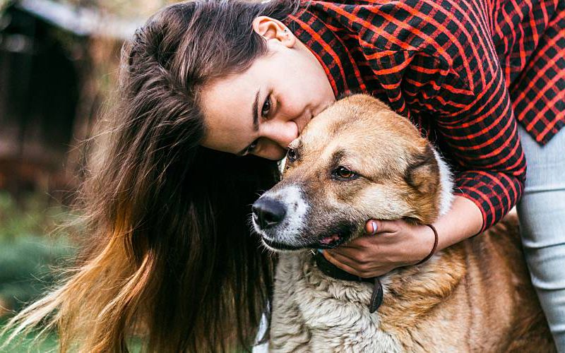 Woman hugging dog.