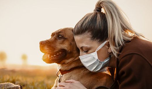 A woman sick with COVID-19 hugs her dog.