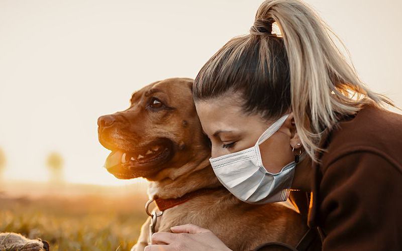 A woman sick with COVID-19 hugs her dog.