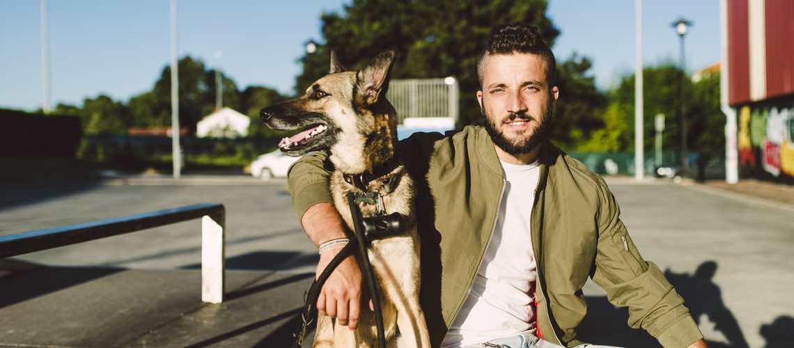 Millennial veterinary client sitting with dog on a bench.