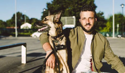 Millennial veterinary client sitting with dog on a bench.