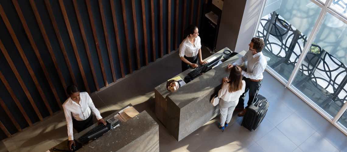 Guests checking in at the hotel reception.